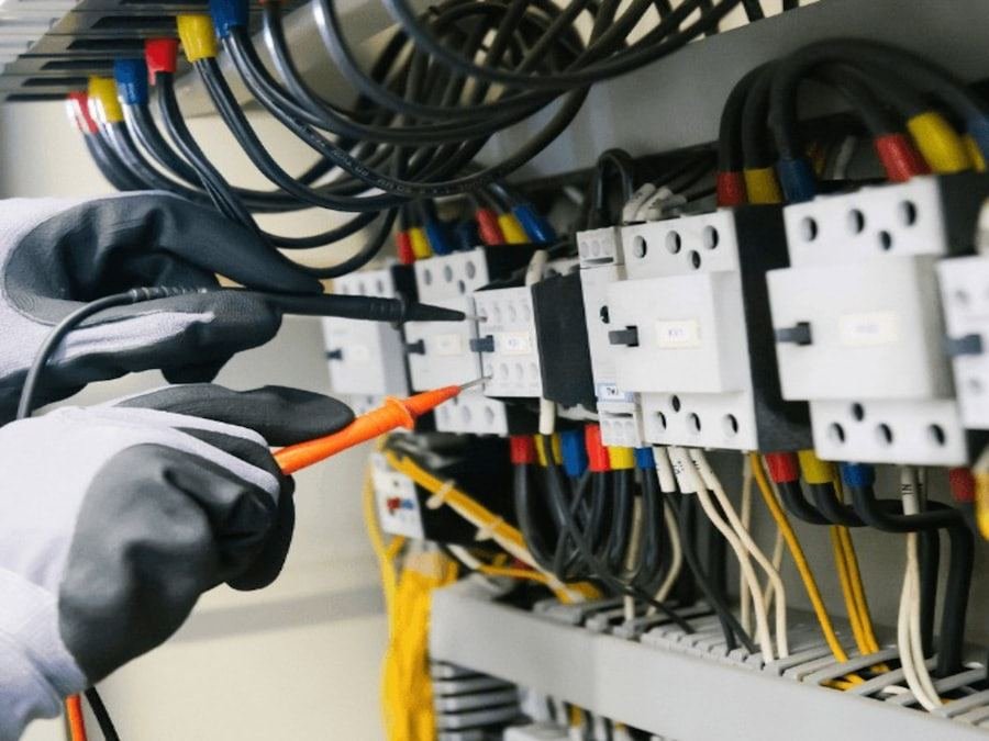 A multimeter probe on a terminal inside an energised distribution board.